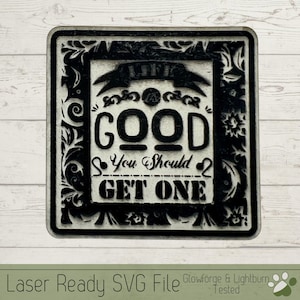 Op de afbeelding: Een zwart-wit bord met een decoratief frame en de tekst "Life is Good You Should Get One".