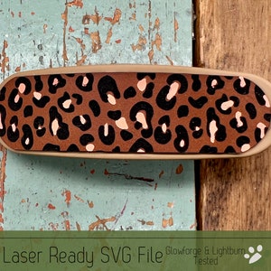 May include: A laser-ready SVG file featuring a brown and black leopard print design with pink accents. The design is perfect for crafting projects using a Glowforge or Lightburn.