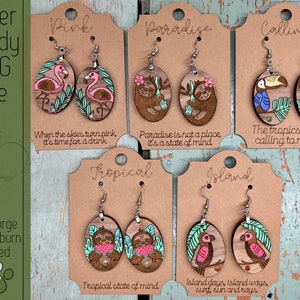 May include: Set of four pairs of wooden earrings with different tropical themes. The earrings feature sloths, flamingos, toucans, and palm leaves. The earrings are laser cut and ready to be painted. The text on the cards reads "Pink", "Paradise", "Calling", "Tropical", and "Island".