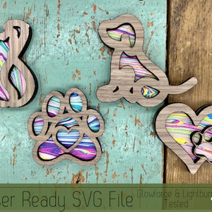 May include: Four laser-cut wooden ornaments with a colorful marbled pattern. The ornaments are shaped like a cat, a dog, a paw print with a heart, and a heart with a paw print inside.