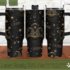 Puede incluir: Un vaso negro y dorado con un diseño sin costuras que presenta el signo del zodíaco Géminis, lunas, estrellas y símbolos celestiales. El vaso tiene una manija negra y una tapa.