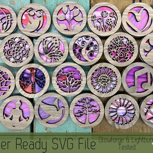 May include: A set of 18 laser-cut wooden coasters with intricate designs. The coasters feature a variety of patterns, including flowers, trees, butterflies, and geometric shapes. The coasters are painted in shades of pink and purple, and have a natural wood finish.  Laser Ready SVG File Glowforge & Lightburn Tested