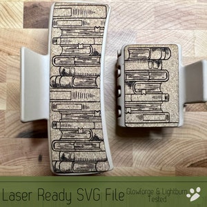 May include: Two beige hair clips with a laser-etched design of stacked books. The design is in black and white and has a vintage look. The clips are on a wooden surface.