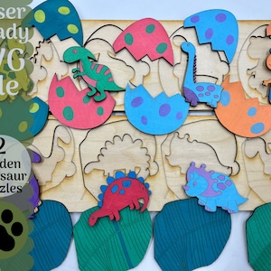 May include: Laser cut wooden puzzle with two hidden dinosaur puzzles. The puzzle pieces are shaped like eggs and dinosaurs. The eggs are painted in various colors, including green, blue, red, and orange. The dinosaurs are painted in various colors, including green, blue, red, and purple. The puzzle is labeled "Laser Ready SVG File" and "2 Hidden Dinosaur Puzzles".