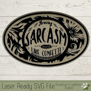May include: Black and white oval-shaped design with the text "Throwing Sarcasm Around Like Confetti!"  The design is on a light brown background.