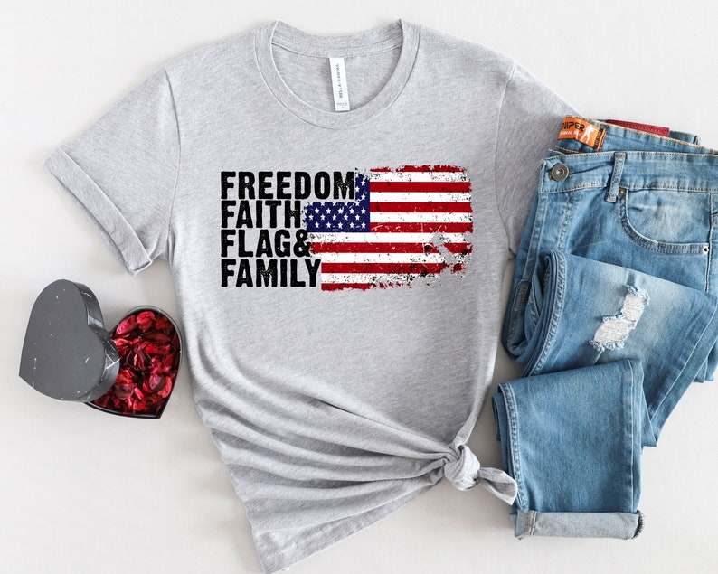 May include: Grey t-shirt with a distressed American flag graphic and the text "FREEDOM FAITH FLAG & FAMILY".