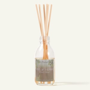 May include: A clear glass reed diffuser bottle containing liquid and five light-colored wooden reeds. The label features the text Tyler Aromatherapy, POT OF HERBS, and Botanical diffuser, with a green leaf graphic on a dark background.