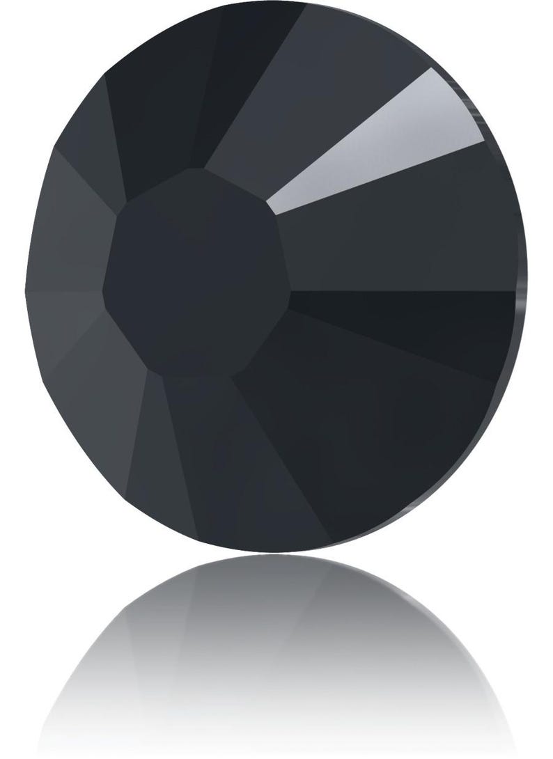 May include: A faceted, round, black gemstone with a reflective surface. The gem has a central, flat facet surrounded by multiple triangular facets, creating a geometric design. The gem's reflection is visible below it.