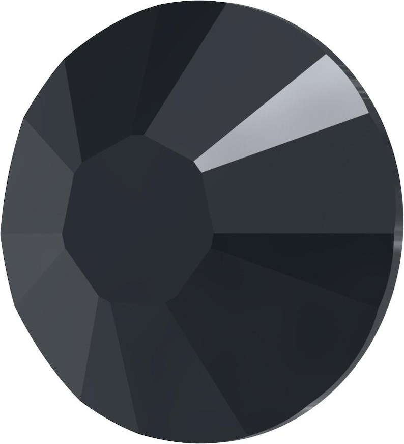 May include: A faceted, dark gray crystal with a circular shape. The crystal has multiple flat surfaces that reflect light, creating a sparkling effect. The crystal's center is a darker shade of gray.