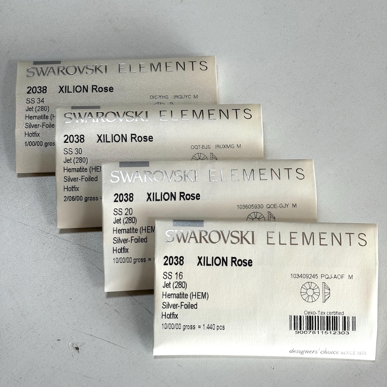 May include: Four packages of Swarovski Elements crystals are stacked. Each package is labeled with the Swarovski Elements logo, the crystal type, and size. The packages are labeled "2038 XILION Rose" and include details like "SS 34", "SS 30", "SS 20", and "SS 16".