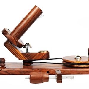 May include: A wooden yarn swift and ball winder set. The set includes a dark brown yarn swift with a vertical spindle, a ball winder with a handle, and a clamp. The text "Heaven of crafts" is visible on the wooden yarn swift.