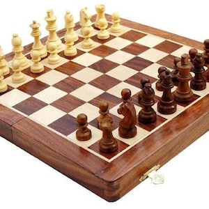 Op de afbeelding: Een houten schaakspel met een schaakbord en schaakstukken. Het bord is bruin en beige, met donkerbruine en lichtbeige vakken. De schaakstukken zijn licht- en donkerbruin. De set is gesloten.