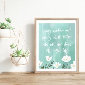 May include: A framed print with a teal watercolor background and white flowers. The print features the text "Surely goodness and mercy shall follow me all the days of my life."