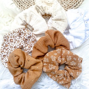 Könnte beinhalten: Ein Set mit sechs Haargummis in verschiedenen Mustern und Farben. Die Haargummis sind aus einem weichen, dehnbaren Stoff gefertigt und haben verschiedene Designs, darunter Leopardenmuster, Blumenmuster und unifarbene Farben. Die Haargummis sind eine großartige Möglichkeit, jedem Outfit einen Hauch von Stil zu verleihen.