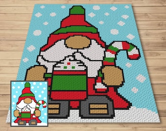 May include: A crochet pattern featuring a gnome holding a cup of hot cocoa with whipped cream and a candy cane. The gnome is wearing a red hat with a green brim, a red and white striped scarf, and brown boots. The background is a light blue with white snowflakes.