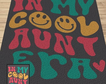May include: A black and white rug with the text "In My Cool Aunt Era" in colorful, retro-style font. The text is surrounded by two yellow smiley faces.