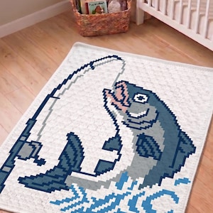 May include: A white rectangular blanket featuring a pixel art graphic of a blue fish being caught on a fishing rod. The fish is depicted in shades of blue and grey with a light pink mouth, while the fishing line and water splashes are blue.