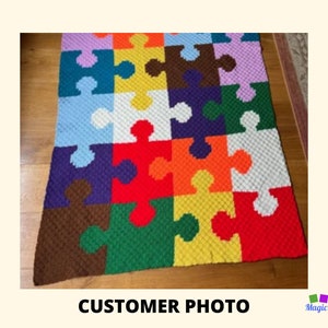 Puede incluir: Una manta de crochet colorida con un diseño de piezas de rompecabezas. La manta está hecha con diferentes colores de hilo, incluyendo rojo, naranja, amarillo, verde, azul, morado y marrón.