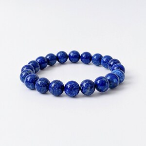 Könnte beinhalten: Ein blaues Lapislazuli-Perlenarmband mit runden Perlen.