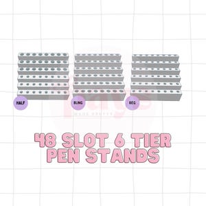 May include: Three gray six-tier pen stands with circular slots, labeled HALF, BLING, and REG in purple circles. The text 48 SLOT 6 TIER PEN STANDS is displayed in large pink letters. The stands are arranged horizontally against a white grid background.