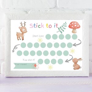 May include: A framed watercolor-style chart with the words "Stick to it" in colorful letters. The chart features a deer, mushroom, and bunny illustration. It has a series of circles for tracking progress and the words "Start here" and "You did it!"