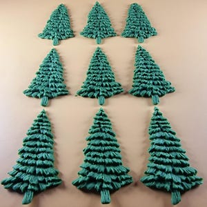 May include: Nine green Christmas tree-shaped decorations arranged in three rows. Each tree has a detailed, textured surface and a small trunk. The trees are a vibrant shade of green, perfect for holiday crafts or decor.