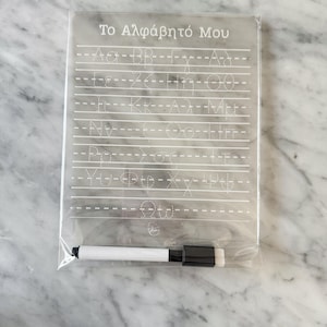 Peut inclure: Tableau d'écriture en plastique transparent avec les lettres de l'alphabet grec et le texte "Το Αλφάβητό Μου". Comprend un marqueur effaçable à sec blanc et noir. Le tableau a des lignes pointillées pour la pratique de l'écriture.