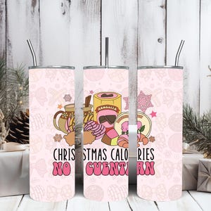 May include: Pink tumbler with a festive design featuring illustrations of pastries, coffee, and other treats. The tumbler has the text "Christmas Calories No Cuentan" in a retro font. Includes a silver straw.