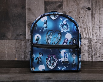 May include: A blue and black backpack with a print of characters from the movie "The Nightmare Before Christmas".