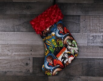 May include: A red and white Christmas stocking with a monster theme. The stocking features a variety of classic monsters, including Frankenstein, Dracula, and the Wolfman. The stocking is made of a soft, plush fabric and has a red fur cuff.