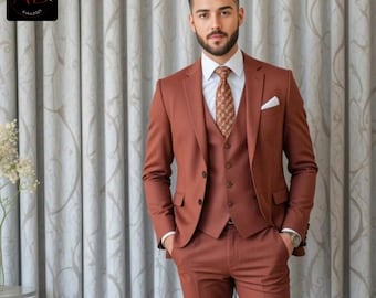 May include: A man wearing a rust-colored three-piece suit with a patterned tie. He is standing in front of a white patterned curtain.