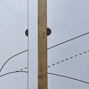 May include: Two white sheets of paper with black lines and circles drawn on them. The sheets are placed side by side on a wooden surface.