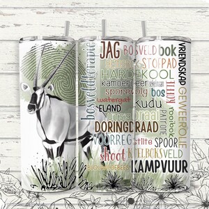 Puede incluir: Un vaso de acero inoxidable con una ilustración de órice en blanco y negro y un diseño de huella dactilar verde. El vaso tiene texto en varios colores, incluyendo "JAG", "BOSVELD" y "KAMPVUUR". Incluye una pajita.
