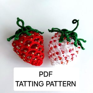 May include: Two crocheted strawberry ornaments, one red with gold beads and the other white with red beads. Both have green stems. The text "PDF TATTING PATTERN" is displayed below the strawberries.