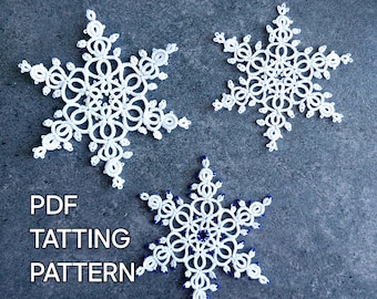May include: Three white, handmade tatting snowflakes on a dark blue-grey background. One snowflake has blue beads. The text "PDF TATTING PATTERN" is in white letters. The snowflakes are delicate and intricate.