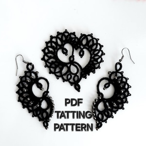 Pode incluir: Um conjunto de padrões de frivolité pretos, com um broche em forma de coração e brincos. Os brincos e o broche são intrincadamente projetados com laços delicados e detalhes de contas. O texto "PDF TATTING PATTERN" é visível.