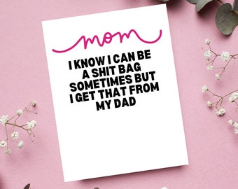 May include: A white card with black text that reads "mom I know I can be a shit bag sometimes but I get that from my dad". The word "mom" is written in pink cursive.