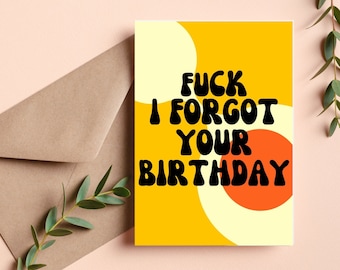 May include: A yellow card with a red and white circle design. The card has black text that reads "FUCK I FORGOT YOUR BIRTHDAY".