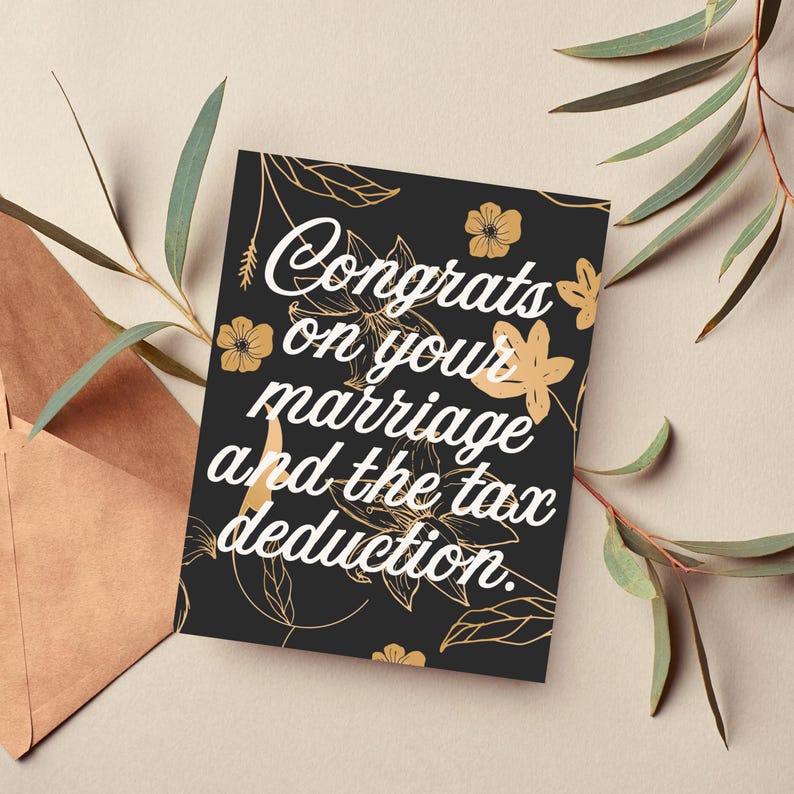 May include: A black card with gold floral designs and white text that reads "Congrats on your marriage and the tax deduction."
