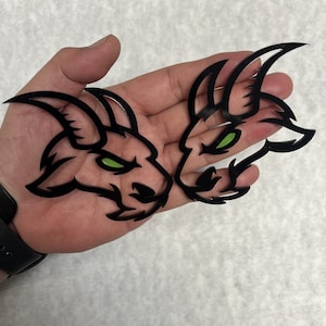 May include: Two black and green goat head decals with sharp horns and angry expressions.