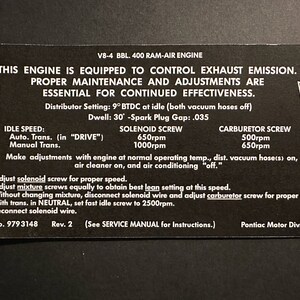 Peut inclure: Une étiquette d'information noire et blanche avec le texte "Ce moteur est équipé pour contrôler les émissions d'échappement. Un entretien et des réglages appropriés sont essentiels pour un fonctionnement continu efficace." L'étiquette comprend également des informations sur le régime de ralenti du moteur, la vis de solénoïde, la vis de carburateur et des instructions pour le réglage du moteur.