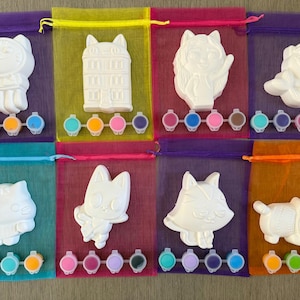 Puede incluir: Ocho kits de cer&aacute;mica para pintar, cada uno con un dise&ntilde;o diferente de animal o arquitectura. Cada kit incluye una figura de cer&aacute;mica blanca y un juego de seis botes de pintura peque&ntilde;os en varios colores. Los kits est&aacute;n empaquetados en bolsas de malla coloridas.