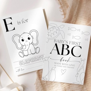 May include: Two black and white children's books. One features an elephant illustration with the text "E is for ELEPHANT". The other book reads "BABY'S FIRST ABC book" with animal illustrations and the text "MADE WITH LOVE BY FAMILY AND FRIENDS!"