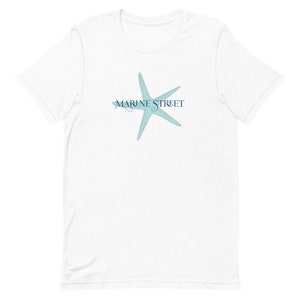 Peut inclure: T-shirt blanc avec une étoile de mer bleue et le texte "MARINE STREET" imprimé sur le devant.