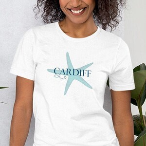 Peut inclure: Un t-shirt blanc avec une étoile de mer bleue et le texte "CARDIFF" imprimé sur le devant.