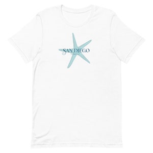 Peut inclure: T-shirt blanc avec une étoile de mer bleue et le texte "SAN DIEGO" en écriture cursive bleue.