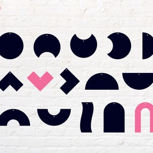 May include: A set of 15 different shapes, including circles, semicircles, hearts, and arrows, with holes for hanging. The shapes are made of black and pink paper.