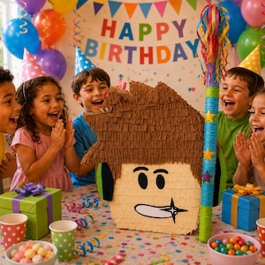 Peut inclure: Une piñata en forme de personnage aux cheveux bruns avec des yeux noirs et une bouche blanche, accompagnée d'un bâton rayé coloré avec des rubans. La piñata présente une texture à franges et des accents verts sur les côtés, posée sur une table.