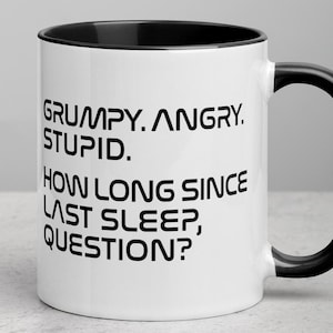 May include: White ceramic mug with a black interior and handle. The mug features the text "GRUMPY. ANGRY. STUPID. HOW LONG SINCE LAST SLEEP, QUESTION?" in black, bold font.