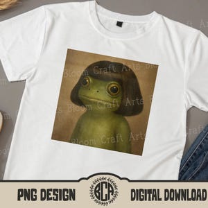 May include: White t-shirt featuring a square graphic of a green frog with a dark brown bob haircut. The frog has large, expressive eyes. The shirt has the text "PNG DESIGN" and "DIGITAL DOWNLOAD".